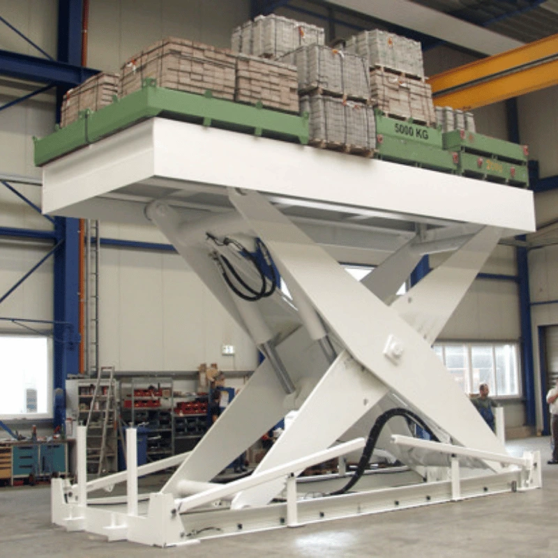 Large scissor lift table with a few crates on it.