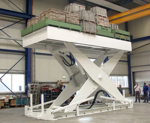 Large scissor lift with crates and boxes on it.
